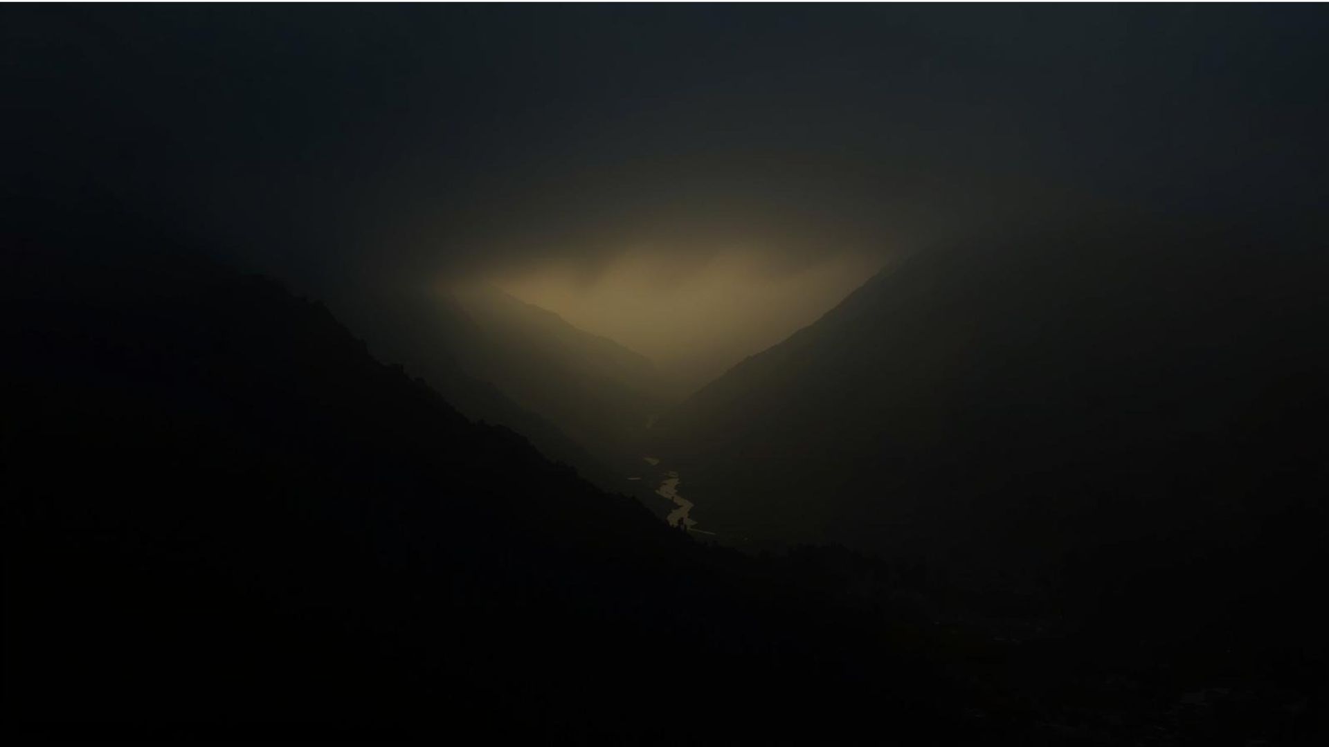 A river of light running through a valley between mountains