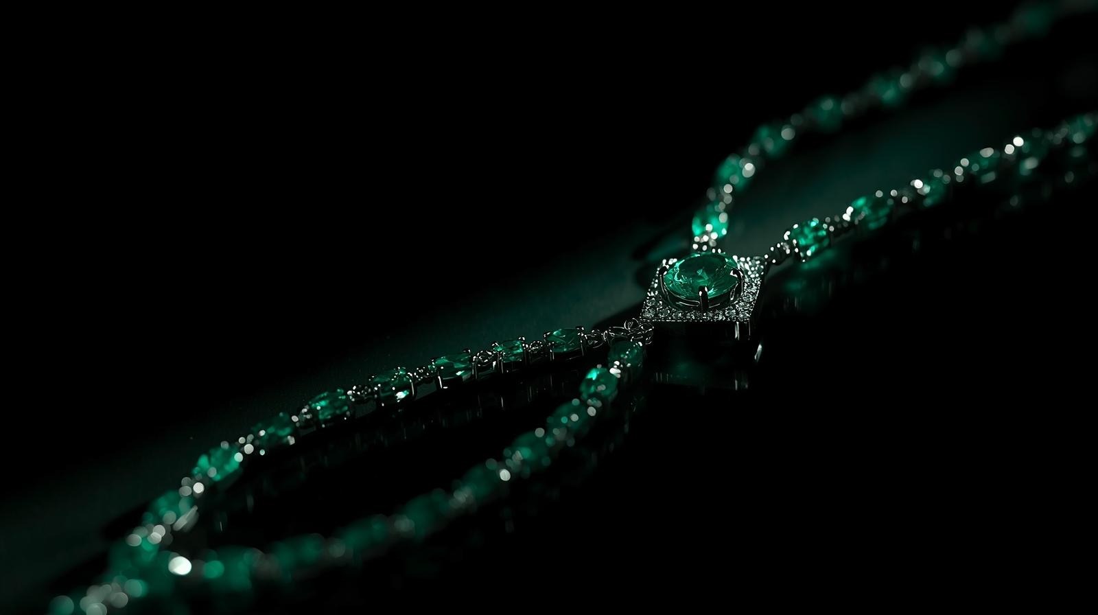 A long rivière necklace of oval emeralds opening onto a square pavé pendant centred on a luminous emerald.